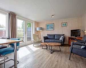 Helles Wohnzimmer von Bungalow Tamarisk 206, Ferienhaus in De Cocksdorp, Texel mit Blick auf den Garten.