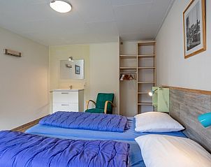 Schlafzimmer mit Waschbecken im Bungalow Tamarisk 206, Ferienhaus in De Cocksdorp, Texel fr zustzlichen Komfort.