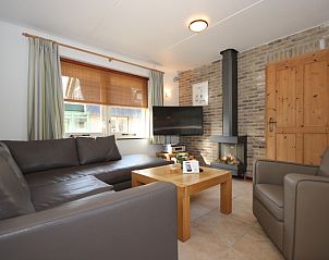 Cozy living room in Villa De Witte Hoek conservatory, vacation home on Texel, with comfortable seating area.
