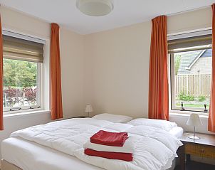 Slaapkamer met tweepersoonsbed in Vuurtorenwachter vakantiehuis, De Cocksdorp, Texel, met tuinzicht.