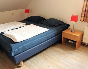 Comfortabele slaapkamer in de Oorsprong, vakantiehuis De Cocksdorp Texel, met tweepersoonsbed en warme inrichting.