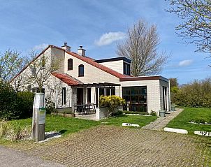 Vakantiehuis D 491 in De Cocksdorp, Texel met zonnige veranda en groene omgeving, ideaal voor een ontspannen verblijf op de Waddeneilanden.