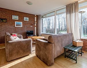 Gezellige woonkamer van Vakantiehuis Slufterhoek 168 in De Cocksdorp, Texel met uitzicht op groen.