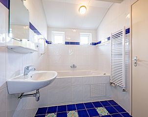 Ruime badkamer met bad in Vakantiehuis Slufterhoek 168, De Cocksdorp, Texel, perfect voor ontspanning.