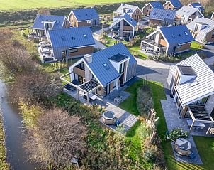 Luftaufnahme eines freistehenden Hauses in De Cocksdorp, Texel, umgeben von Natur und modernen Ferienhusern auf den Watteninseln.