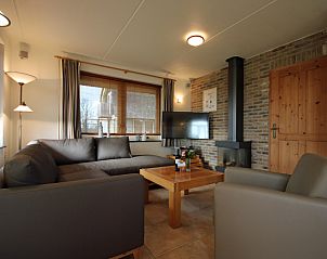 Gezellige woonkamer in Villa De Witte Hoek, De Cocksdorp, Texel met comfortabele zithoek en open haard voor een ontspannen verblijf.