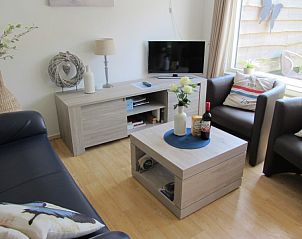 Gezellige woonkamer in vakantiehuis De Vlinder, De Cocksdorp, Texel, met comfortabele zithoek en decoraties.