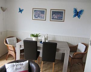 Eetkamer in vakantiehuis De Vlinder, De Cocksdorp, Texel, met stijlvolle inrichting en kunst aan de muur.