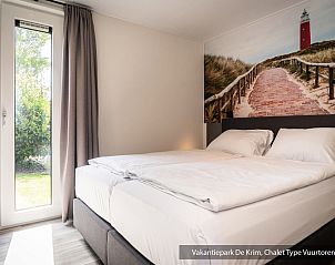 Stijlvolle woonkamer in Chalet Type Vuurtoren de Luxe, De Cocksdorp, Texel, met grote ramen.