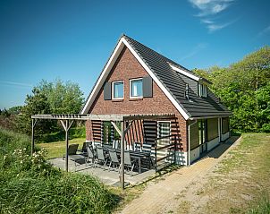 Sfeervolle setting met wijn bij de open haard in Sluftervallei bungalow, Texel.