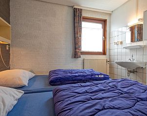 Schlafzimmer mit zwei Betten im Ferienhaus Slufterhoek 056, De Cocksdorp Texel, ausgestattet mit Waschbecken.