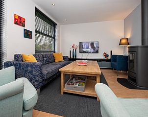 Gezellige woonkamer in Vakantiehuis Slufteroord 240, Texel met comfortabele zithoek en moderne inrichting.