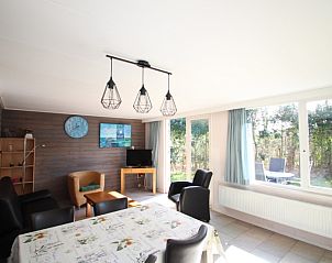 Sfeervolle woonkamer van Bungalow Tamarisk 196, De Cocksdorp, Texel, met toegang tot het terras.