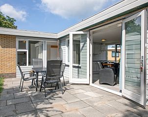 Zonnig terras van Bungalow Tamarisk 196, De Cocksdorp, Texel, ideaal voor buitenmaaltijden en ontspanning.