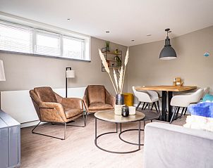 Stijlvolle zitruimte in Type C Appartement de Stoeterij, De Cocksdorp, Texel met comfortabele fauteuils en decoratieve elementen.