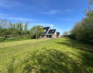 Uitgestrekte groene tuin van Familiehuis Dacha in De Cocksdorp Texel, perfect voor rust en natuurbeleving op de Waddeneilanden.