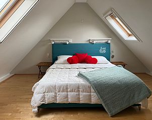 Gezellige slaapkamer in Familiehuis Dacha, De Cocksdorp Texel, met comfortabel bed en dakramen voor een ontspannen verblijf.