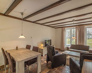 Gezellige woonkamer in Type R vakantiehuis, De Cocksdorp, Texel, met grote ramen en comfortabele zitplaatsen.