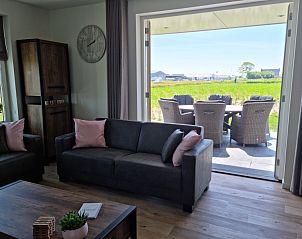 Zithoek in Vakantiehuis Texel, De Cocksdorp, met openslaande deuren naar het zonnige terras.
