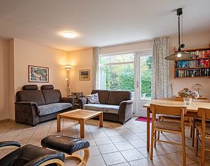 Gezellige woonkamer van Vakantiehuis Slufterduin 094 in De Cocksdorp, Texel, met comfortabele zithoek en uitzicht op de groene tuin.