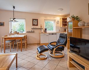 Gezellige woonkamer in Vakantiehuis Slufterduin 094, De Cocksdorp, Texel. Comfortabele zitruimte en moderne keuken in een sfeervolle omgeving.
