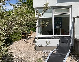 Zonnig hoekje met ligstoel bij Bungalow Schelpenoord - Vakantiehuis De Oester, De Cocksdorp, Texel, ideaal voor ontspanning.