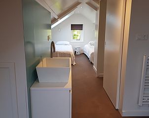 Zolderkamer met twee bedden in Bungalow Schelpenoord - Vakantiehuis De Oester, De Cocksdorp, Texel, met dakraam en modern interieur.