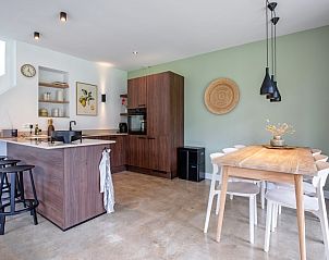 Dining area in Holiday home De Razende Bol, De Cocksdorp, Texel, with wooden table and comfortable chairs.