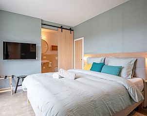 Luxury bedroom in Holiday home De Razende Bol, De Cocksdorp, Texel, with king-size bed and modern decoration.