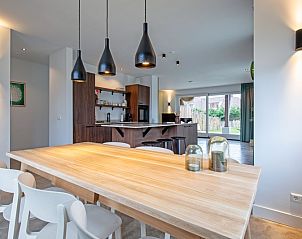 Esszimmer des Ferienhauses Griend, Texel mit Holztisch und stimmungsvoller Beleuchtung.