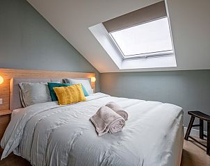 Schlafzimmer im Ferienhaus Griend, Texel mit bequemem Bett und Dachfenster.