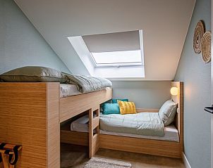 Gemtliches Kinderzimmer im Ferienhaus Griend, Texel mit Etagenbett und Dachfenster.