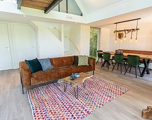 Stilvolles Wohnzimmer des Ferienhauses Zeewinde in De Cocksdorp, Texel, mit moderner Einrichtung und Essecke.