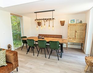 Stilvolles Esszimmer im Ferienhaus Zeewinde, De Cocksdorp, Texel mit Holztisch und stimmungsvoller Beleuchtung.