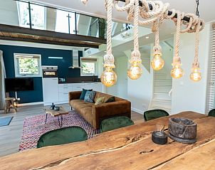 Stimmungsvolle Beleuchtung ber dem Esstisch im Ferienhaus Zeewinde, De Cocksdorp, Texel mit Blick auf das Wohnzimmer.