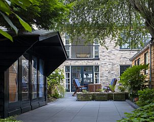 Gezellige binnenplaats van Het Kwade Konijn vakantiehuis in De Cocksdorp, Texel, omgeven door natuur.