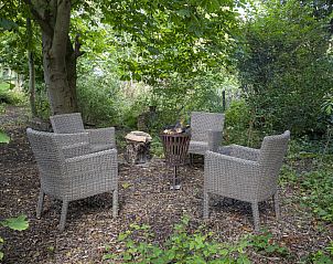 Rustieke buitenruimte van Het Kwade Konijn vakantiehuis in De Cocksdorp, Texel, omringd door groen.