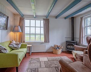 Gezellige woonkamer van vakantiehuis Muyweg 062 in De Cocksdorp, Texel met uitzicht op groene velden.