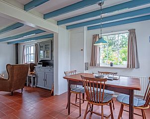 Eetkamer in vakantiehuis Muyweg 062, De Cocksdorp, Texel met houten tafel en stoelen voor gezellige maaltijden.