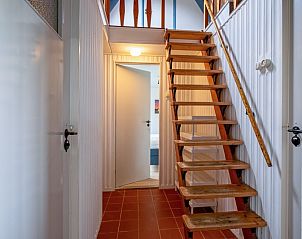 Houten trap in vakantiehuis Muyweg 062, De Cocksdorp, Texel leidt naar bovenverdieping.