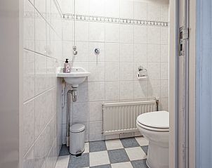 Compacte badkamer in vakantiehuis Muyweg 062, De Cocksdorp, Texel met toilet en wastafel.