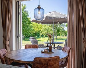 Eethoek met uitzicht op de tuin bij Appartement B in De Cocksdorp, Texel, ideaal voor buiten dineren.