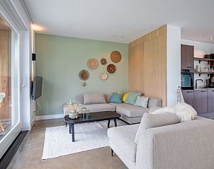 Stylish interior of Holiday Home Brakzand in De Cocksdorp, Texel, with comfortable sitting area and open kitchen.