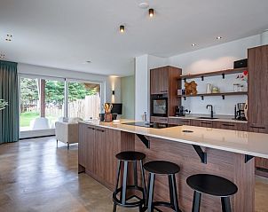 Modern kitchen in Holiday home Brakzand, De Cocksdorp, Texel, with island and views of the green surroundings of the Wadden Islands.