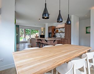 Dining room with wooden table in Holiday home Brakzand, De Cocksdorp, Texel, perfect for cozy dinners on the Wadden Islands.