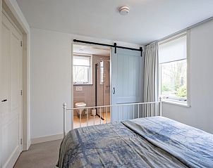 Slaapkamer met ensuite badkamer in Bungalow Postweg 109, De Cocksdorp, Texel. Luxe vakantiehuis op de Waddeneilanden.