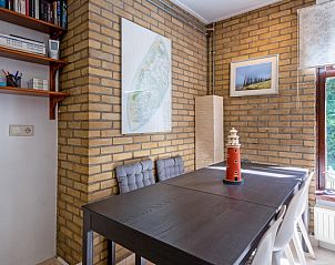 Eethoek in Vakantiehuis Slufterduin 092, De Cocksdorp, Texel met moderne inrichting en uitzicht op de groene omgeving.