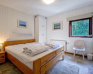 Sfeervolle slaapkamer in Vakantiehuis Slufterduin 092, De Cocksdorp, Texel met comfortabel tweepersoonsbed en rustige ambiance.