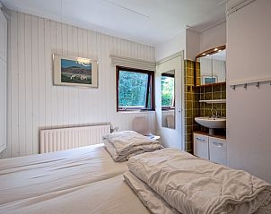 Lichte slaapkamer met ensuite badkamer in Vakantiehuis Slufterduin 092, De Cocksdorp, Texel, voor een ontspannen verblijf.