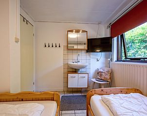 Moderne badkamer in Vakantiehuis Slufterduin 092, De Cocksdorp, Texel, met wastafel en spiegel voor comfort tijdens je verblijf.